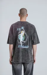 Remera negra con efecto nevado, de corte oversize y manga corta. Estampa circular en el pecho con la frase "Tarot Luxo El Mundo" y un dibujo del planeta Tierra.