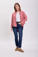 Camisa a rayas verticales rojas y blancas, de corte holgado y mangas largas con puños abotonados.