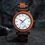 Reloj Chenaut Perle d’Ébène con caja de madera de sándalo rojo, esfera blanca perlada con manecillas azules y malla de madera de ébano.