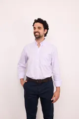 Camisa celeste con rayas verticales blancas, de corte clásico, con cuello abotonado, manga larga y bolsillo en el pecho.