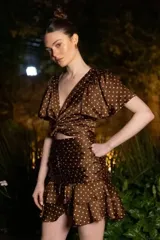 Top marrón con lunares blancos, escote en V, mangas cortas amplias y lazo central.