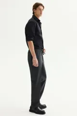 Camisa negra de manga larga con cuello italiano y tapeta lisa. Presenta un corte ajustado (slim fit) y bajo redondeado.