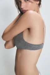 Conjunto de ropa interior color crema, compuesto por un corpiño triangular de algodón con encaje en el escote y una bombacha tipo bikini con encaje en la cintura.