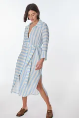 Vestido camisero largo a rayas horizontales verdes y blancas, con cuello clásico, mangas 3/4 y abertura frontal con botones. Confeccionado en lino.