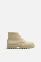 Bota de hombre color beige de cuero serraje con cordones, puntera redonda y suela track.
