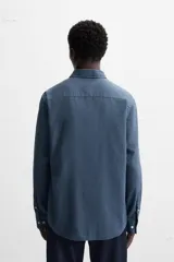 Camisa de vestir azul petróleo, corte regular, confeccionada en mezcla de algodón. Cuenta con cuello solapa, mangas largas con puños abotonados y cierre frontal con botones.