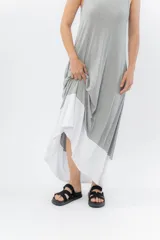 Vestido largo negro con base blanca, de corte suelto y sin mangas.