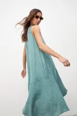 Vestido midi verde agua de lino, corte evasé, sin mangas y con bolsillos laterales.