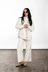 Sobrecamisa de lino y algodón a rayas verticales color crudo, con cuello camisero, cierre frontal con botones y bolsillos de parche en el pecho.