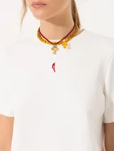 Remera blanca de jersey pesado con escote redondo, mangas cortas y bordado de un ají rojo en el frente.