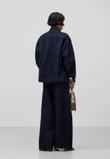 Chaqueta tipo kimono de denim de algodón color azul oscuro, con cuello kimono, cierre cruzado con lazos laterales, mangas amplias con puños y bajo recto.