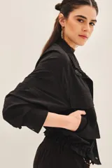 Campera negra con jareta ajustable en el ruedo con cordón de colores, presilla interna en las mangas y bolsillos en el delantero.