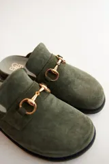 Mocasines tipo sueco de cuero gris con detalle de hebilla dorada.