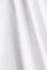 Musculosa blanca de punto acanalado de algodón, corte ajustado, con cuello redondo y sisas ribeteadas.
