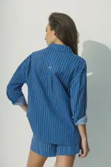 Camisa marrón a rayas verticales negras y rojas, de corte relaxed, con cuello clásico y botones al tono.