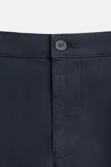 Pantalón chino azul marino, corte skinny fit, confeccionado en tejido de algodón con elasticidad. Cuenta con bolsillos frontales y traseros de vivo. Cierre frontal con cremallera y botón.