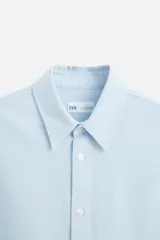 Camisa azul marino de algodón con textura jacquard, corte relaxed fit, cuello solapa, manga larga con puños abotonados y cierre frontal con botones.