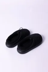 Pantuflas negras acolchadas con interior de piel sintética y ajuste con cordón elástico.