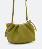 Bolso pequeño color verde oliva, desestructurado, con pinzas frontales y cierre de botón a presión. Incluye una correa de hombro extraíble y un asa de mano decorada con cuentas acrílicas variadas en tonos blancos, marrones y transparentes.