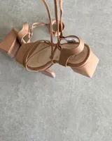 Sandalias de tacón de 9 cm, con diseño minimalista y tiras delgadas en color nude.