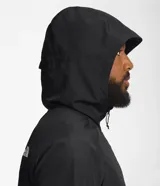 Campera negra con capucha, resistente al viento, con cierre frontal y bolsillos laterales. Logotipo de The North Face estampado en blanco en el pecho y en la espalda.