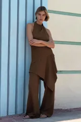 Top marrón de cuello halter con textura y drapeado lateral. Espalda y bajo asimétricos. Cierre en cuello con botones.