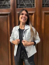 Chaqueta plateada metalizada con cuello camisero, cierre frontal con botones, bolsillos de parche en el pecho y corte recto.