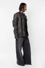Chaqueta de cuerina pu opaca efecto vintage gastada, de silueta “oversize”. Acceso delantero mediante cierre metálico desmontable color dark niquel, con cartera interna pespunteada en zig zag de misma tela base. Cuello mao con snap y hombreras matelaseadas. Bolsillos delanteros con cierre metálico dark niquel Los ubicados en la parte superior son falsos. Terminación en manga con cierre metálico dark niquel para ajustar puño Por su interior, forrería matelaseada y bolsillo oculto en lado izquierdo superior con cierre invisible.
