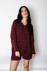 Poncho de lurex color borgoña con calce suelto y mangas largas. Tejido y diseñado en Uruguay.
