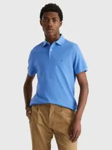 Chomba azul de Tommy Hilfiger, modelo 1985, de corte regular, con cuello tipo chomba, cartera de dos botones, logo bordado en el pecho y confeccionada en mezcla de algodón y poliéster.