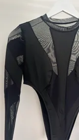 Body negro de mangas largas confeccionado en tejido de punto con transparencias.