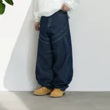 Pantalón jean azul oscuro, corte ultra baggy, tiro alto y diseño con costuras a la vista.