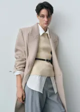 Chaleco de punto grueso color beige, sin mangas y con cuello redondo. Tejido con mezcla de lana responsable y corte slim fit.