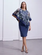 Vestido azul de seda fría, marca RM Richards. Tiene una sobre capa en microtul bordado con flores.