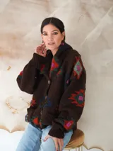 Saco de lana marrón con diseño geométrico multicolor, cuello con solapa, cierre frontal con botones y bolsillos delanteros.