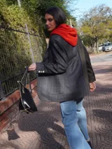 Blazer oversize con diseño asimétrico que combina dos tweeds contrastantes: uno marrón liso y otro blanco y negro con estampado pata de gallo. Tiene botones de strass y un pin de salchicha.