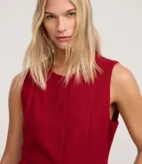 Chaleco rojo con cuello redondo, sin mangas y cierre frontal con botones forrados.