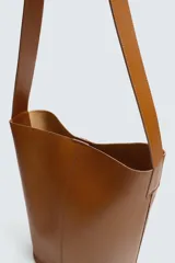 Bolso tipo shopper negro fabricado en piel, con asa de hombro y cierre magnético.