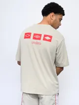 Remera color arena de corte holgado, con cuello redondo y logo de Umbro estampado en el pecho.