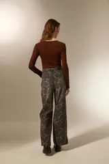 Pantalón de jean azul claro con estampado abstracto desgastado, corte baggy y tiro medio.