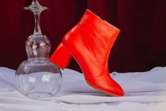 Botas plateadas de cuero con caña media, cierre lateral con cremallera y tacón geométrico.