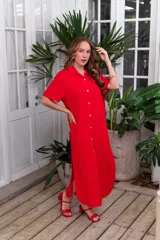 Vestido camisero de muselina color negro, de largo midi, con cuello clásico, manga corta y cierre frontal con botones.