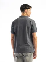 Remera polo verde con cuello y mangas con borde blanco, confeccionada en algodón.