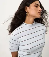 Blusa de ribana color beige con rayas horizontales negras, cuello medio y mangas cortas.