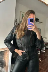Campera corta de cuero negro con costuras desgastadas y corte tipo bomber.