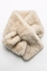 Bufanda de pelo sintético color beige con diseño cruzado.