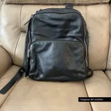 Mochila negra de cuero vacuno con forro de gabardina de algodón, compartimento acolchado para laptop de hasta 14 pulgadas, bolsillo frontal con cierre y cierres metálicos plateados.