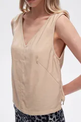 Blusa color beige de poliéster, al cuerpo y con cuello en V.