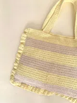 Bolso tipo tote tejido a crochet, con hilo 100% algodón, a rayas horizontales color crema y lila, con volados en los bordes y manijas reforzadas.
