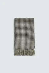 Bufanda rectangular con estampado de cuadros en tonos beige y negro, con flecos en los extremos.